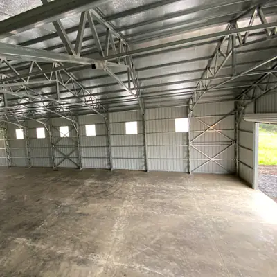 Large clear-span metal building interior with windows