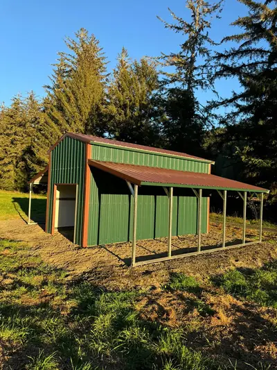 Green barn-style garage with a lean-to running the full length